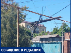На одной из улиц Таганрога аварийный столб висит на проводах несколько дней