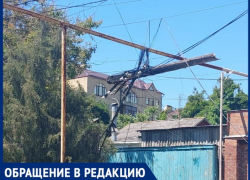 На одной из улиц Таганрога аварийный столб висит на проводах несколько дней